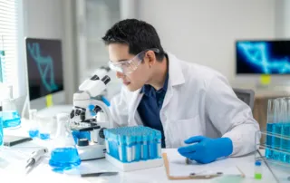 a man in a lab coat is looking at a microscope