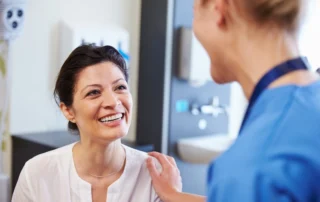 female patient being reassured by doctor in hospital room